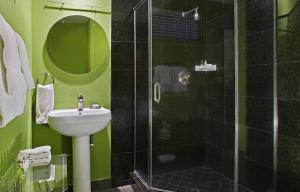 a green bathroom with a sink and a shower at 7 Springs Inn & Suites in Palm Springs