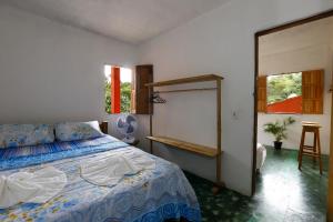 a bedroom with a bed and a table and two windows at Casa Trancosinho in Trancoso