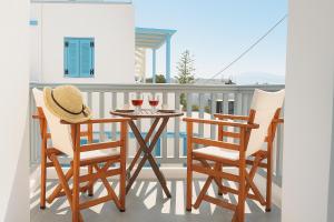 a table and chairs on a balcony with wine glasses at Ale appartment in Agios Prokopios