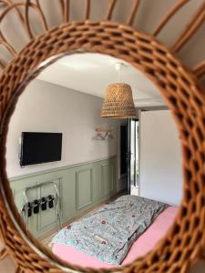 a mirror in a room with a bed and a tv at Au gré des vents in Saint-Quay-Portrieux