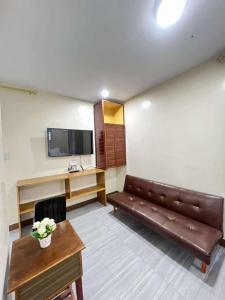 a room with a couch and a table and a tv at Good Living Baguio manage by Baguio Terra Realty and Devt Corp in Baguio