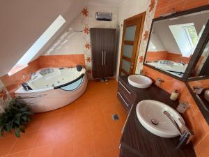 a bathroom with a large tub and two sinks at Villa Tin & Koča Tin - Nature, Water and Peace in Prestranek