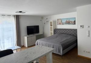 a bedroom with a bed and a flat screen tv at Ferienwohungen Akwant in Baden-Baden