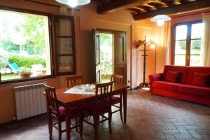 ガンバッシ・テルメにあるApartments Borgo Toscanoのリビングルーム(テーブル、赤いソファ付)