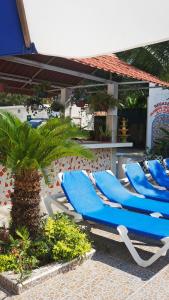 two blue lounge chairs under an umbrella on a patio at Hotel Maricarmen in Manzanillo