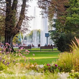 people sitting on a park bench in front of a fountain at PANNONIA Budapest Center DELUXE in Budapest