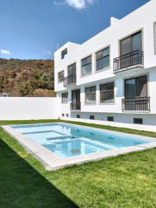 an apartment building with a swimming pool in front of a building at Nuevos departamentos en Valle de Bravo in Valle de Bravo