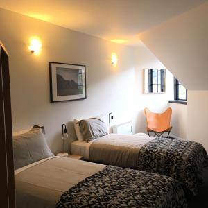 a bedroom with two beds and a chair in it at House of Ullr in Thredbo