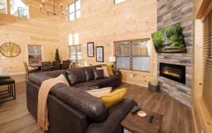 sala de estar con sofá de cuero y chimenea en A Pools Paradise, en Pigeon Forge