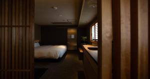 um quarto com uma cama e um lavatório num quarto em Higashiyama Shikikaboku em Quioto