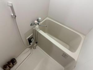 a white bath tub in a small bathroom at Pk箱崎 in Fukuoka