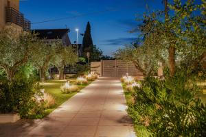 einen Gehweg in einem Garten mit Bäumen und Sträuchern in der Unterkunft Lea Residenza Mediterranea Paestum in Paestum