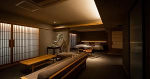 um quarto de hotel com um banco e uma cama em Higashiyama Shikikaboku em Quioto
