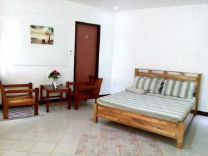 a bedroom with a bed and two chairs and a table at Gazebo Pools and Restaurant in Cabadbaran