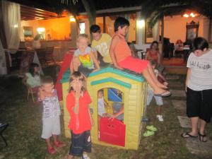 a group of children standing around a play house at Alessandro in Sidari