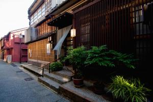 a building with plants on the side of a street at Kazueya in Kanazawa