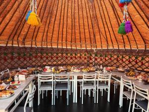 a long table with chairs and food in a tent at One Million Stars Yurt camp in Song-Kul