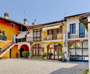 un grupo de edificios con balcones y mesas en Antica Dimora Polpenazze, en Polpenazze del Garda