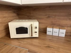 a white microwave sitting on top of a wooden floor at Apartament Mickiewicza - PKP Station in Przemyśl