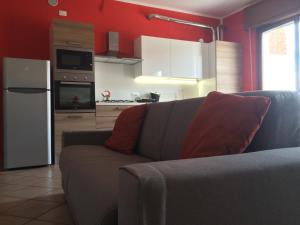 sala de estar con sofá y cocina en Appartamento Arco, en Lazise