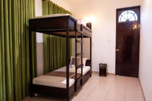 a bunk bed in a room with green curtains at Tribe Hostel in Kandy
