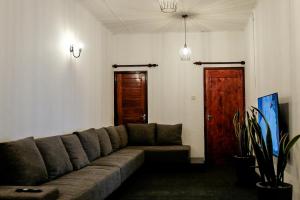 a living room with a couch and a wooden door at Tribe Hostel in Kandy