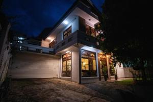 a large white house with lights on it at night at Tribe Hostel in Kandy