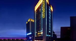 a tall building with lights on it at night at Gaosu New Century Hotel International Anhui in Hefei