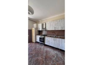 a kitchen with white cabinets and stainless steel appliances at дом в Махинджаури in Makhinjauri