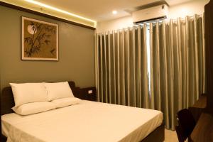 a bedroom with a bed and a window with curtains at Street-facing room 2BR Balcony Elegance Home in Hanoi +57 photos