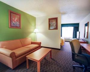 a living room with a couch and a table in a hotel room at Quality Inn & Suites Airport in Austin