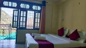 a large bed in a room with a large window at Hotel Nanak bharmour manimahesh in Brāhmaur