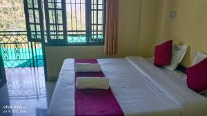 a large bed in a room with two pillows on it at Hotel Nanak bharmour manimahesh in Brāhmaur +1 photo