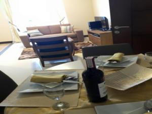 uma mesa com uma garrafa de vinho e um copo de vinho em Mactan Newtown Executive Studio em Mactan
