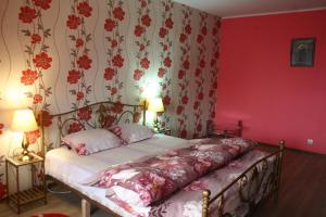 a bedroom with a bed with red walls and a floral wallpaper at Salonul Rosu in Bacău