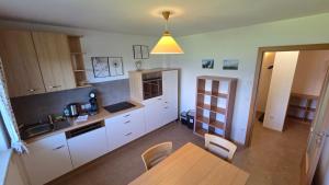 a kitchen with white cabinets and a wooden table at Haus Tauernseitn in Schladming