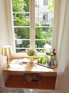 ein Fenster mit einem Tablett mit Äpfeln auf einem Fensterbrett in der Unterkunft Lovely-Flats "Gasteiner" in Berlin