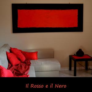 a living room with a couch and a red painting on the wall at B&B il rosso e il nero in Zafferana Etnea