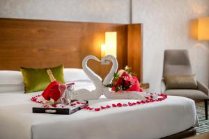 uma cama com dois cisnes e flores em Jumeira Rotana – Dubai em Dubai