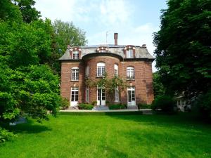 une ancienne maison en briques rouges avec une pelouse verte dans l'établissement Queen Christine, à Villeneuve d'Ascq