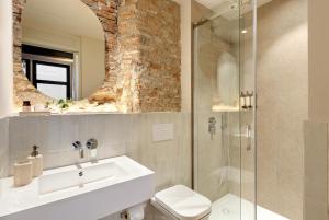 a bathroom with a sink and a glass shower at Coeo Santa Maria Cathedral Signature Apartments in Málaga +37 photos