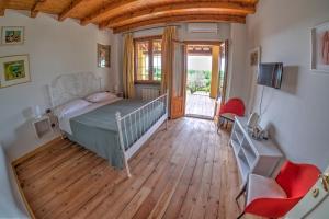 イゼーオにあるAgriturismo Villa Antonellaのベッドと木の床のある寝室