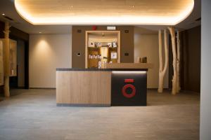 a lobby with a counter with a red on it at Monroc Hotel in Commezzadura