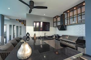 a kitchen and living room with a ceiling fan at Luxury 6BR Seaview Statement Villa - Villa Legend in Ban Saiyuan (1)
