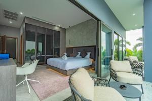 a bedroom with a bed and a living room at Luxury 6BR Seaview Statement Villa - Villa Legend in Ban Saiyuan (1) +47 photos