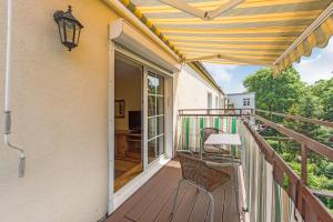 eine Terrasse mit Tisch und Stühlen auf einem Deck in der Unterkunft Apartament Classic z balkonem in Sopot