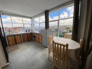 a kitchen with a table and a large window at Apartment with 360-degree view in Antananarivo