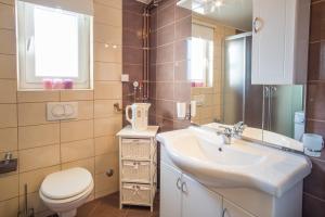 a bathroom with a sink and a toilet and a mirror at Apartment Ivana 2435 in Malinska +32 photos