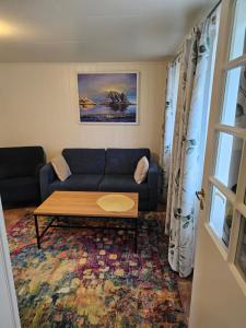 a living room with a blue couch and a coffee table at Apartment at Lofoten. Mølnarodden. in Sund