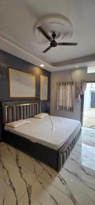a large bed in a room with a ceiling fan at Muskan home stay in Ujjain +2 photos